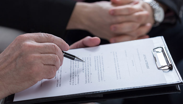 man holding a form for registering a death