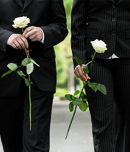 2 men holding a rose for a funeral